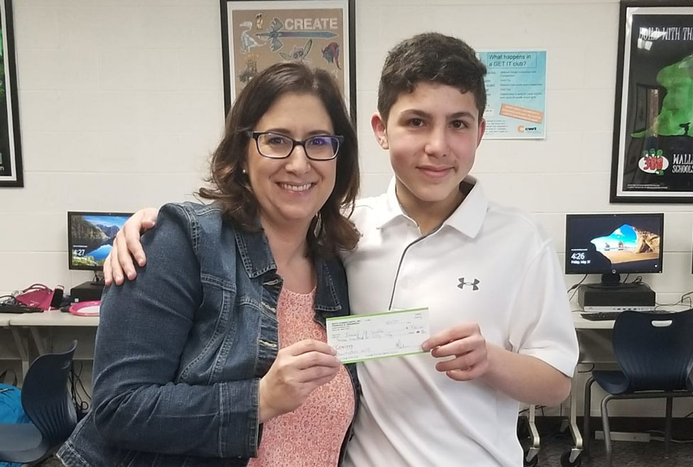 Yousef and Mrs. Harpe holding the prize money.